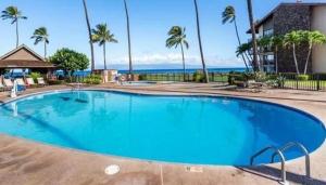 a large blue swimming pool with the ocean in the background at Oceanfront Remodeled-30 Feet to Ocean-Central AC-Highly Sought After in Lahaina