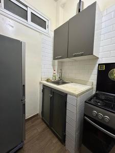 a small kitchen with a sink and a stove at Charmant Studio front de terre Dakar in Dakar