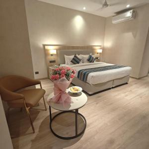 a hotel room with a bed and a table with flowers at Bluestone Prime by The Cosy Hotels in New Delhi +94 photos