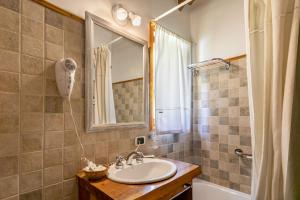 une salle de bains avec lavabo, miroir et baignoire dans l'établissement BOG Altos de Antilhue - Apart con vista al bosque, à Villa La Angostura