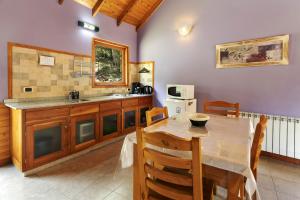 une cuisine avec une table, un évier et un comptoir dans l'établissement BOG Altos de Antilhue - Apart con vista al bosque, à Villa La Angostura