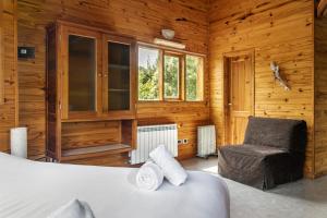une chambre avec un lit et une chaise dans l'établissement BOG Altos de Antilhue - Apart con vista al bosque, à Villa La Angostura 50 autres photos