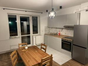a kitchen with a wooden table and a dining room at Apartament Siedlce ul Szkolna 4 in Siedlce