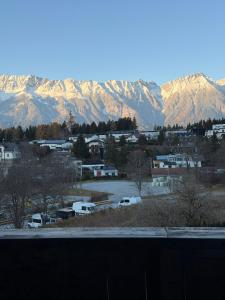 a parking lot with snow covered mountains in the background at Hotel Gruberhof Innsbruck Igls B&B in Innsbruck