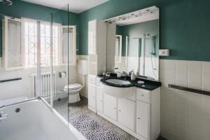 un bagno con vasca, lavandino e WC di La casa del Pucci a Lucca Altre 46 foto