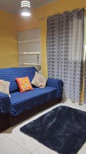 a blue couch in a living room with a window at Casa Lari milagres in São Miguel dos Milagres
