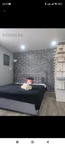 une chambre avec un grand lit et un mur en pierre dans l'établissement квартира Центр, à Semey 3 autres photos