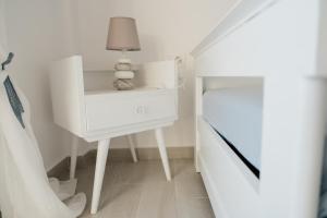 a white table with a lamp on it next to a bed at Agapi in Xylokastro
