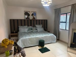 ein Schlafzimmer mit einem großen Bett mit einem hölzernen Kopfteil in der Unterkunft VinVid Harties Guest House in Hartbeespoort