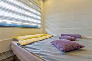 a bed in a room with pillows and a window at Jazz apartman Titova vila in Zlatibor +47 photos