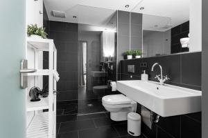 uma casa de banho em preto e branco com um lavatório e um WC em Global Living - Design Apartment I Rathausplatz I Kitchen I Augsburg em Augsburg mais 82 fotografias