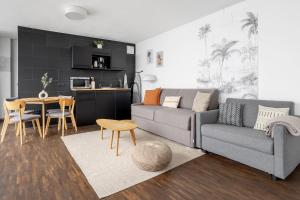 uma sala de estar com um sofá e uma mesa em Global Living - Design Apartment I Rathausplatz I Kitchen I Augsburg em Augsburg