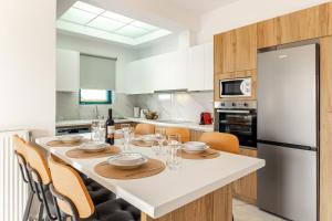 a kitchen with a table with chairs and a refrigerator at Villa Sandi with Private Pool in Hersonissos