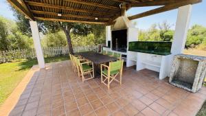 eine Terrasse mit einem Tisch, Stühlen und einem Grill in der Unterkunft Holiday Home Finca Binimazoch in Port d'Addaia