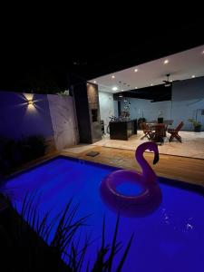 uma piscina à noite com um cisne na água em Casa Temporada Aconchego e tranquilidade 3 em Bonito