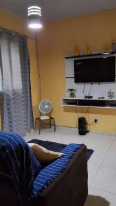 a living room with a couch and a flat screen tv at Casa Lari milagres in São Miguel dos Milagres +19 photos
