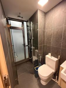 a bathroom with a toilet and a shower at Infinitum Luxurious Sky Suites in Kuala Lumpur