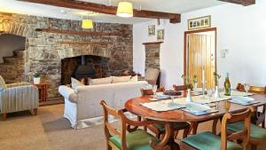 a living room with a table and a couch at Lower Lock Cottage in Llangynidr