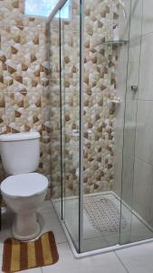 a bathroom with a toilet and a glass shower at Casa Lari milagres in São Miguel dos Milagres +19 photos