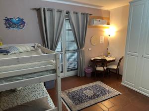 a bedroom with a bunk bed and a table and a window at B&B Filomena in Santa Giusta
