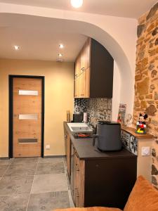 eine Küche mit einer Steinmauer und einem Torbogen in der Unterkunft BullyCosy in Bully