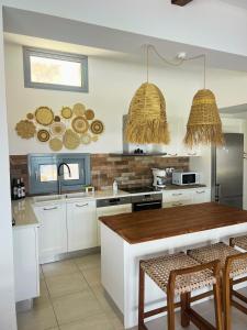 a kitchen with white cabinets and a wooden counter top at Villa Aristoteles in Líndos