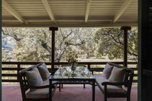 - une table et deux chaises sur une terrasse couverte avec vue dans l'établissement Lithies Organic Farm, à Vasilikos