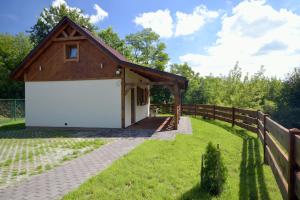 a barn with a white garage and a fence at Jaśminowe Wzgórze in Sandomierz