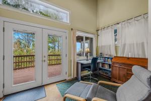 a living room with a desk and a chair and a window at Above Sleepy Hollow - Rooftop Deck, Amazing Views, Hot Tub, Pet Friendly, Screen Porch, Wifi, EV Station, Games, Trails, Wood Stove, Charcoal Grill, Lake Access, King Bed in Hedgesville