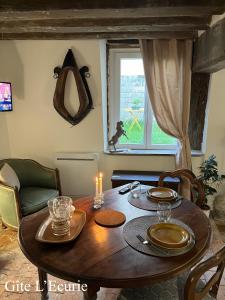 een eettafel met een kaars en een raam bij Le Grand Faubourg les Gîtes Ecurie et La Faïencerie in Lorris +48 foto's