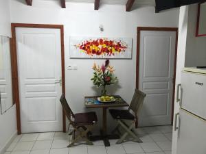 eine Küche mit einem Tisch mit einer Vase mit Blumen darauf in der Unterkunft Corail rouge in Sainte-Anne + 1 Foto