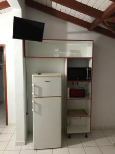 eine Küche mit Kühlschrank und Mikrowelle in der Unterkunft Corail rouge in Sainte-Anne