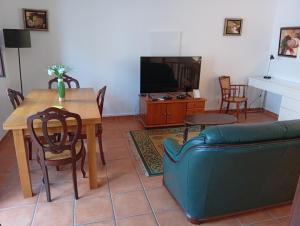 a living room with a couch and a table and a tv at Casa próxima da praia fluvial in Mourão