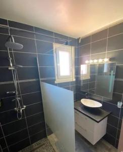 a blue tiled bathroom with a sink and a mirror at Magnifique villa moderne Jacuzzi 4 chambres 3 salle de bain proche plage centre ville activité in Le Barcarès +18 photos