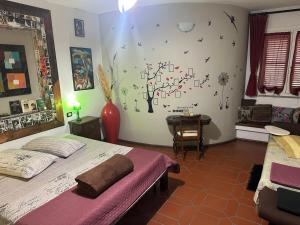 a bedroom with two beds and a tree on the wall at B&B Filomena in Santa Giusta
