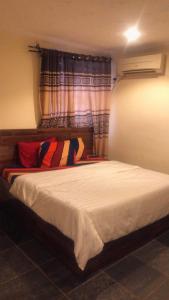 Un dormitorio con una gran cama blanca con ventana. en Noblelite Hotels, en Gwarinpa