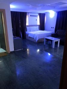 Un dormitorio con una cama, un sofá y una mesa. en Noblelite Hotels, en Gwarinpa 1 foto más