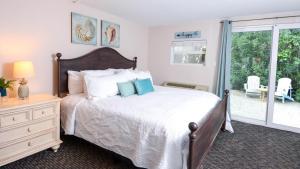 een slaapkamer met een bed, een ladekast en een raam bij 701 Mariners Club in Key Largo +42 foto's