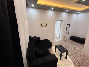 Una sala de estar con un sofá negro y una mesa. en Masal home, en Alexandroupoli