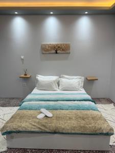 Una cama con dos zapatillas blancas encima. en Masal home, en Alexandroupoli