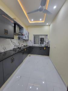 a kitchen with a white tile floor and a ceiling at Airport Gateway Guesthouse in Rawalpindi