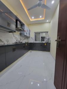 a kitchen with a ceiling fan and a white tile floor at Airport Gateway Guesthouse in Rawalpindi