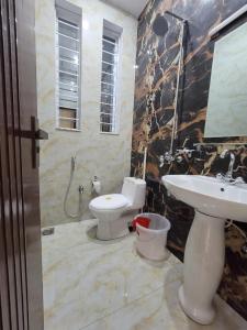 a bathroom with a toilet and a sink at Airport Gateway Guesthouse in Rawalpindi +22 photos