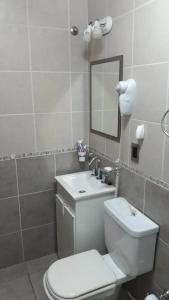 拉斯格路塔斯La Perla的浴室里有白色马桶和洗手池