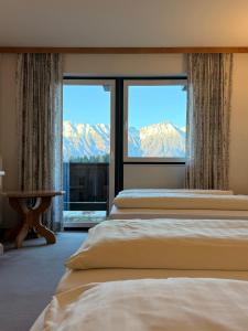 a bedroom with two beds and a view of mountains at Hotel Gruberhof Innsbruck Igls B&B in Innsbruck