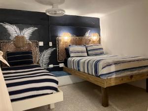 une chambre avec deux lits avec des oreillers rayés dans l'établissement Trade Winds Restaurant & Guest House, à Vieques