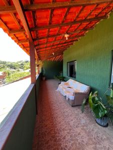 un balcone con un letto su una parete verde di Apartamentos e Suites Casa Verde a Búzios