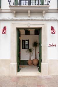 Tür zu einem Gebäude mit zwei Topfpflanzen in der Unterkunft Estudio Lola4 in Lucena