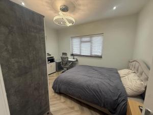 ein Schlafzimmer mit Bett, Schreibtisch und Fenster in der Unterkunft Luxurious Bedroom and Living room in a House in Romford