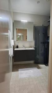 ein Badezimmer mit Badewanne, Waschbecken und Dusche in der Unterkunft Villa near the sea in a scenic area in Mariehamn in Mariehamn + 10 Fotos